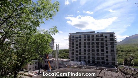 An exhibitionist GIRL walks on a construction site